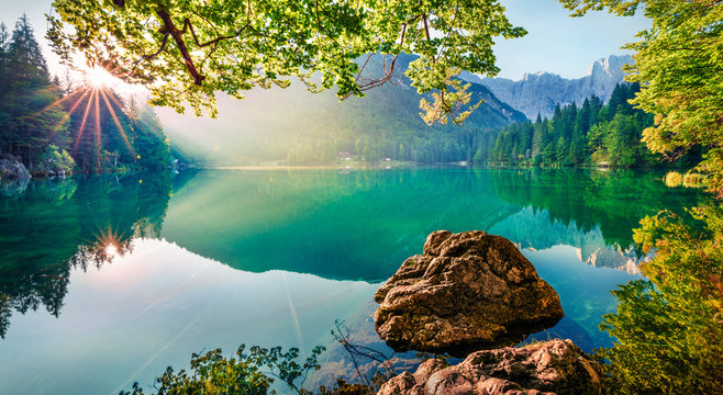 Impressive morning view of Fusine lake. Attractive summer scene of Julian Alps with Mangart peak on background, Province of Udine, Italy, Europe. Traveling concept background.
