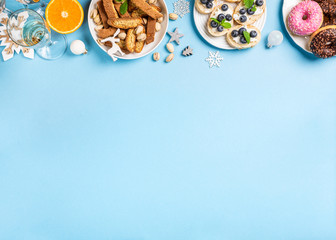 Chtistmas holiday food concept background with dinner party table over blue, top view, flat lay with copy space