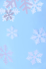 Winter background. White snowflakes cut from white paper on a blue background.