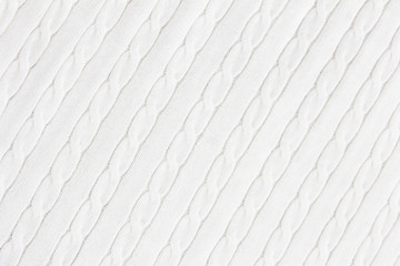 texture of knitted woolen white fabric with a pigtail pattern