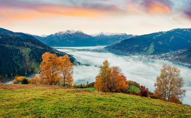 Fantastic view of Zell lake. Impressive autumn sunrise of Austrian town - Zell am See, south of the city of Salzburg. Beauty of nature concept background.
