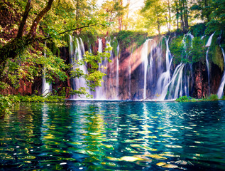 Last sunlight lights up the pure water waterfall on Plitvice National Park. Colorful spring scene of green forest with blue lake. Great countryside view of Croatia, Europe. 