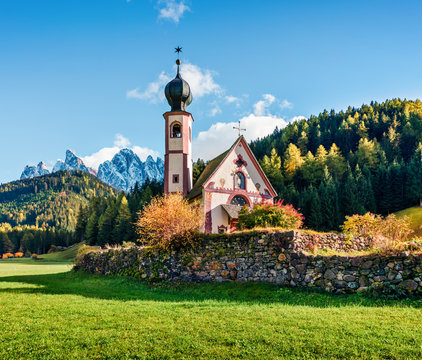 Splendid view of Chiesetta di San Giovanni in Ranui church in front of the Geisler, Santa Magdalena village location. Colorful autumn scene of Dolomite Alps, Italy, Europe. 