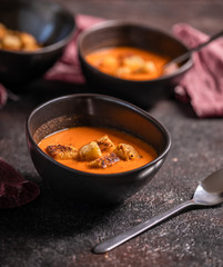 Vegetarian delicious autumn pumpkin cream soup served in beautiful rustic bowls