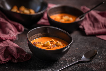 Vegetarian delicious autumn pumpkin cream soup served in beautiful rustic bowls