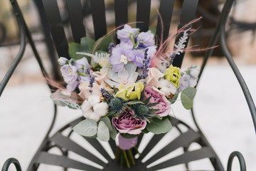 Beautiful modern bridal bouquet of colorful fresh flowers with sikl ribbons. Classic wedding traditional accessory.