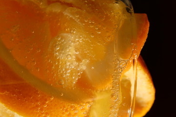 Obraz na płótnie Canvas orange cut into slices in a glass of sparkling water.