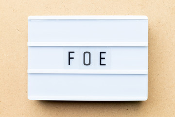 White lightbox with word foe on wood background