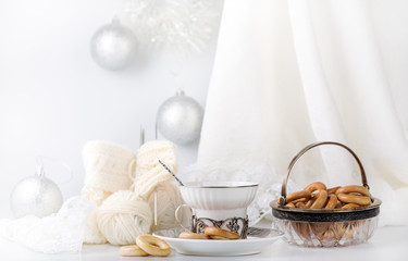 composition with light Christmas decorations, tea and bread rings