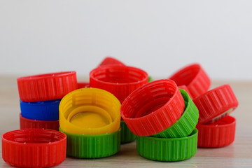 Multicolored plastic caps on wooden background