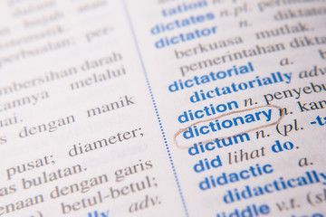 close up of a marked or highlited DICTIONARY word in english to malay dictionary. translator and language concept. selective and soft focus