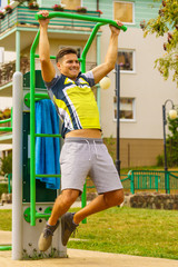 Man doing pull ups in outdoor gym