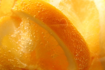 orange cut into slices in a glass of sparkling water.
