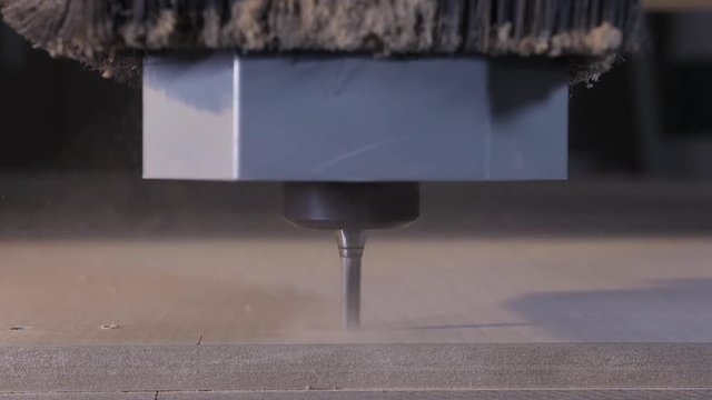 Close up of woodworking process, CNC milling machine, manufacture concept. Action. Drilling tool in wood factory with the wooden flying dust.