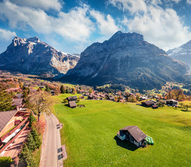 Splendid autumn view of Grindelwald village valley from cableway. Wetterhorn and Wellhorn...