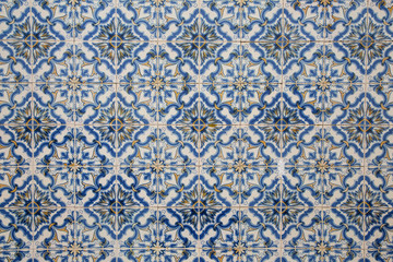 Ornate pattern, for design, backdrop. Abstract background from decorative painted tiles, close up. Fragment of old building wall, with traditional Portuguese, glazed ceramic tiles. White and blue colo