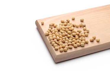 Organic soybeans on wooden cutting, chopping board, isolated on white background