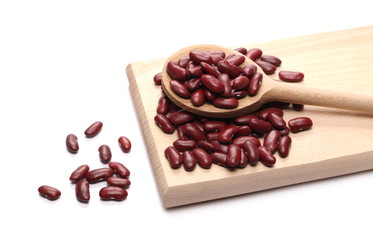 Fototapeta premium Red beans in wooden spoon on cutting, chopping board isolated on white background