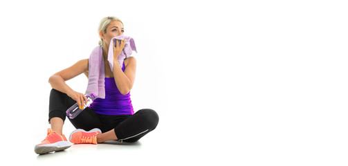 A young sports girl with blonde hair in a black sports axe, black leggings and bright sneakers with...