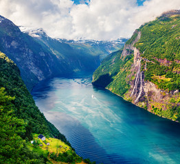 Splendid summer scene of Sunnylvsfjorden fjord, Geiranger village location, western Norway. Beautiful morning view of famous Seven Sisters waterfalls. Beauty of nature concept background.