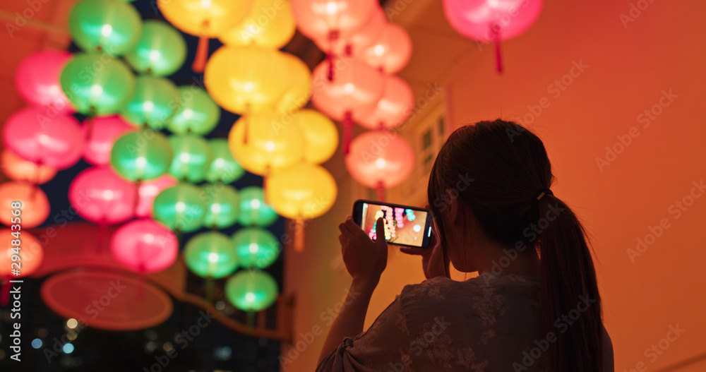 Poster woman take photo with cellphone on the chinese lantern