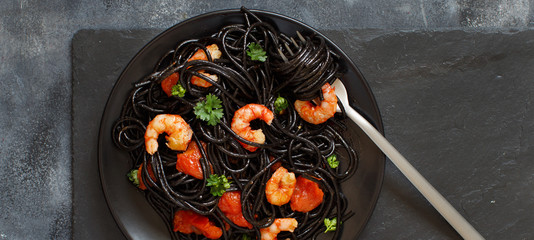Squid ink pasta with prawns and tomatoes