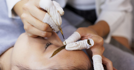Obraz na płótnie Canvas Microblading procedure, master work on woman eyebrow