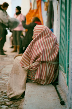mujer africana sentada en la calle con bruca