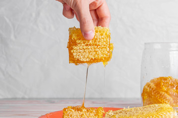 Honeycombs in the hands of which flow out sticky sweet honey - 294844540