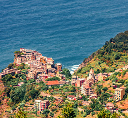 Third village of the Cique Terre sequence of hill cities - Corniglia. Sunny spring morning in Liguria, Italy, Europe. Picturesqie seascape of Mediterranean sea. Traveling concept background.