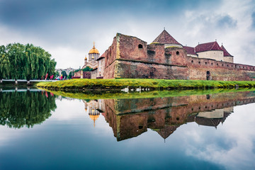 Naklejka na ściany i meble Great summer view of medieval Fagaras Citadel. Picturesque morninng scene of Transylvania, Romania, Europe. Traveling concept background.