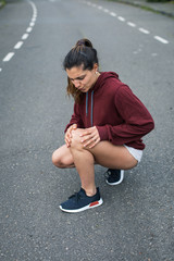 Female athlete suffering from running knee painful injury.