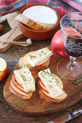 Apples and Camembert cheese bread toast and glass of red wine