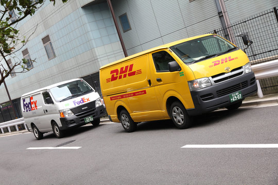 TOKYO - MAY 9: FedEx and DHL vans parked on May 9, 2012 in Tokyo. FedEx and DHL are direct competitors in many markets and are among 3 largest courier companies worldwide with UPS.