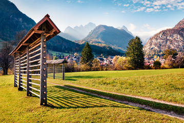 Incredible autumn view of Triglav mountain range and Gozd Martuljek village. Sunny morning scene of Julian Alps, Slovenia, Europe. Beauty of nature concept background..