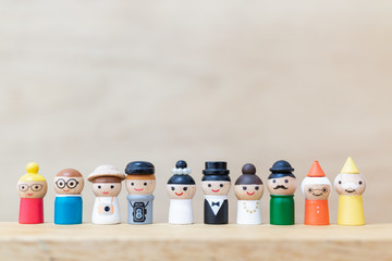 Miniature toy : cute wooden doll with  happy face on wooden background