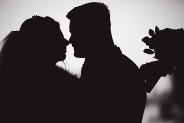 Silhouette of groom and bride. Black and white photo