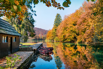 Stunning morning view of pure water lake with boats in Plitvice National Park. Amazing autumn scene of Croatia, Europe. Beauty of nature concept background.
