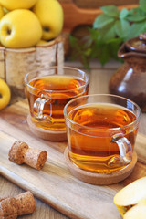 Two cups of Apple Cider and yellow apples
