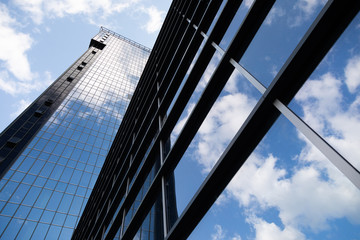 Fototapeta na wymiar Bottom view of glass building reflecting sky