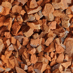 Repeating seamless background of broken orange brick fragments