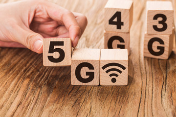 5G (5th Generation) network connecting technology future global. Hand flip wood cube change number 4G to 5G