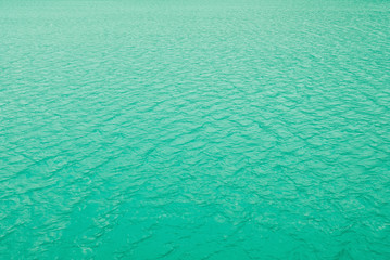 Clean transparent water surface of mountain lake texture for background. Neo mint color trend of the year 2020.