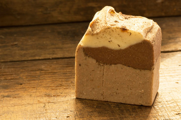 Natural handmade soap with cocoa and cinnamon on wooden background and copy space