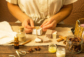Woman hands wrap natural handmade soap with cocoa and cinnamon