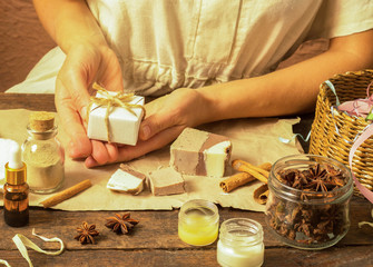 Woman hands wrap natural handmade soap with cocoa and cinnamon