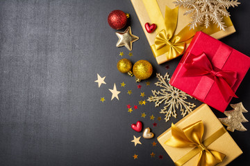 Golden and red gift boxes with shiny satin bow and christmas decorations