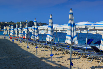 Obraz premium Morning sea beach with deck chairs and umbrellas in sand