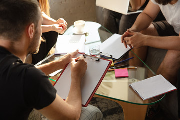 Group of young caucasian office workers meeting to discuss new ideas. Creative meeting. Teamwork and brainstorming. Men and women meet in office to plan their future working. Business concept.