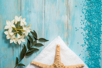 Spa and wellness setting with flowers, and white towel on old wooden background. Blue dayspa nature set. copyspace. Vacation concept. flat lay. top view.
